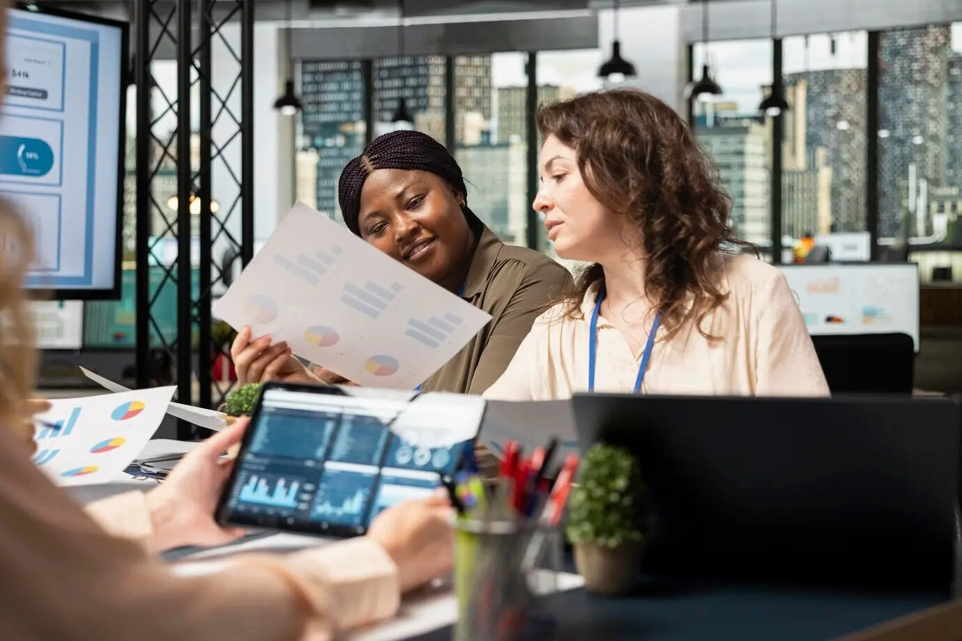Un grupo de asociados de negocios se reúne en la sala de juntas para alinear los objetivos de desempeño con los indicadores del proyecto.