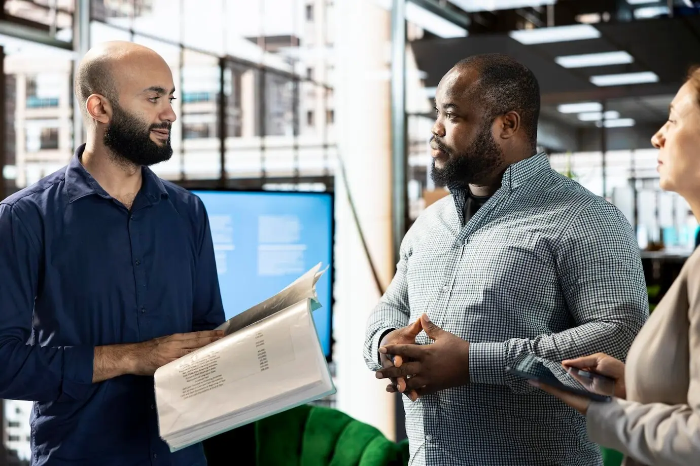 Equipo diverso de empleados de oficina revisando cifras contables en la documentación.